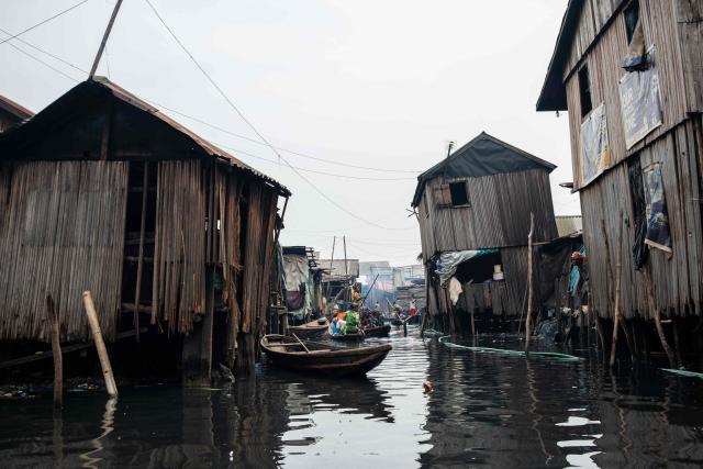 People in pirogues navigate their way in Makoko, a floating slum in Lagos, on January 9, 2026. Authorities have demolished hundreds of wooden shacks in Makoko, Africa’s largest and most iconic floating slum, which is built on stilts above the lagoon in the heart of Lagos. The operation is part of an ongoing campaign to remove what officials describe as illegal structures and reclaim waterfront land for modern real-estate developments. (Photo by TOYIN ADEDOKUN / AFP)