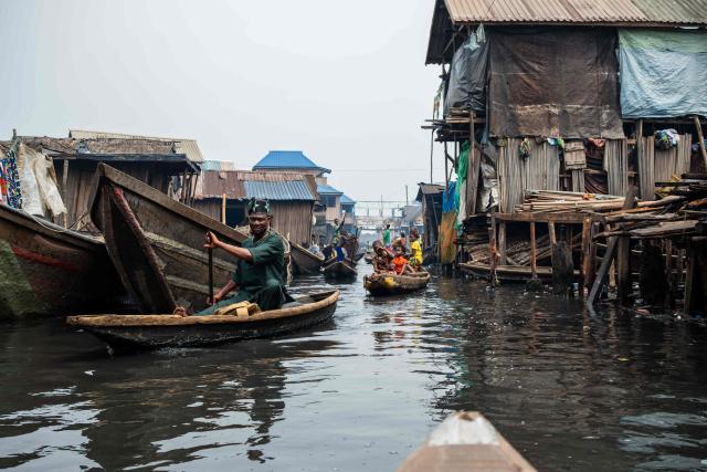 People in pirogues navigate their way in Makoko, a floating slum in Lagos, on January 9, 2026. Authorities have demolished hundreds of wooden shacks in Makoko, Africa’s largest and most iconic floating slum, which is built on stilts above the lagoon in the heart of Lagos. The operation is part of an ongoing campaign to remove what officials describe as illegal structures and reclaim waterfront land for modern real-estate developments. (Photo by TOYIN ADEDOKUN / AFP)