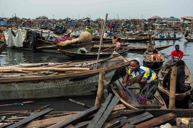 A resident evacuates planks during the demolition in Makoko, a floating slum in Lagos, on January 9, 2026. Authorities have demolished hundreds of wooden shacks in Makoko, Africa’s largest and most iconic floating slum, which is built on stilts above the lagoon in the heart of Lagos. The operation is part of an ongoing campaign to remove what officials describe as illegal structures and reclaim waterfront land for modern real-estate developments. (Photo by TOYIN ADEDOKUN / AFP)