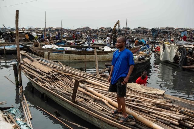 Alex Wusa, 25, poses for a picture during demolition of houses in Makoko, a floating slum in Lagos, on January 9, 2026. Authorities have demolished hundreds of wooden shacks in Makoko, Africa’s largest and most iconic floating slum, which is built on stilts above the lagoon in the heart of Lagos. The operation is part of an ongoing campaign to remove what officials describe as illegal structures and reclaim waterfront land for modern real-estate developments. (Photo by TOYIN ADEDOKUN / AFP)