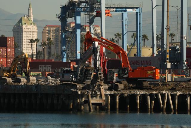 The downtown Long Beach skyline stands on the horizon as a demolition crew removes debris on the Pier G South Slip Fill project on the ITS Terminal at the Port of Long Beach in Long Beach, California on January 14, 2026. (Photo by Patrick T. Fallon / AFP)