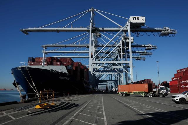 A truck moves a cargo shipping container from a ship docked at the International Transportation Service (ITS) terminal at the Port of Long Beach in Long Beach, California on January 14, 2026. (Photo by Patrick T. Fallon / AFP)