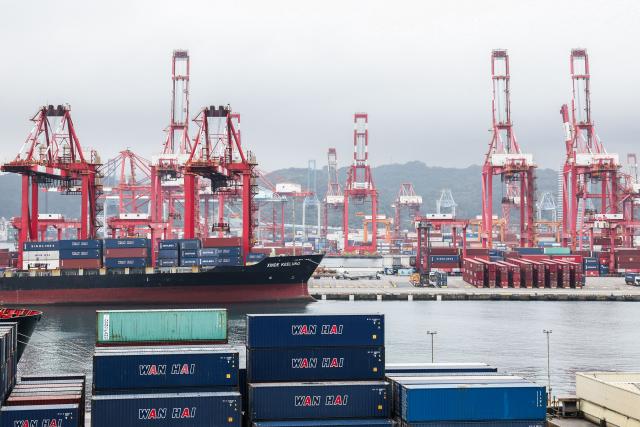 Gantry cranes and shipping containers are seen at the port in Keelung on January 16, 2026. The United States said on January 15 that it has signed a deal with Taiwan to reduce tariffs on goods from the democratic island, while increasing Taiwanese semiconductor and tech companies' investments in America. (Photo by I-Hwa Cheng / AFP)