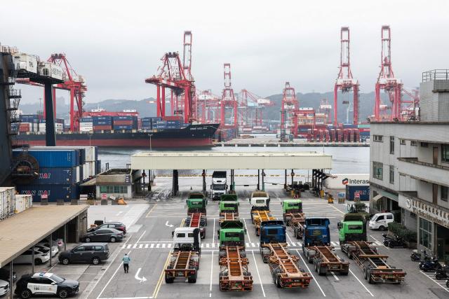 Gantry cranes and shipping containers are seen at the port in Keelung on January 16, 2026. The United States said on January 15 that it has signed a deal with Taiwan to reduce tariffs on goods from the democratic island, while increasing Taiwanese semiconductor and tech companies' investments in America. (Photo by I-Hwa Cheng / AFP)