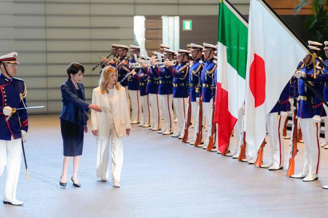 Italy's Prime Minister Giorgia Meloni (C) and Japan's Prime Minister Sanae Takaichi inspect honour guards at the prime minister's official residence in Tokyo on January 16, 2026. (Photo by Toru HANAI / POOL / AFP)