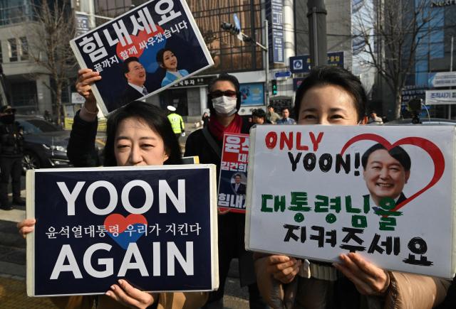 Supporters of South Korea's impeached former president Yoon Suk Yeol gather in front of the Seoul Central District Court in Seoul on January 16, 2026. A South Korean court will rule on January 16, on whether former president Yoon Suk Yeol obstructed justice during his disastrous martial law declaration and in its chaotic aftermath, the first in a series of verdicts for the disgraced ex-leader. (Photo by Jung Yeon-je / AFP)