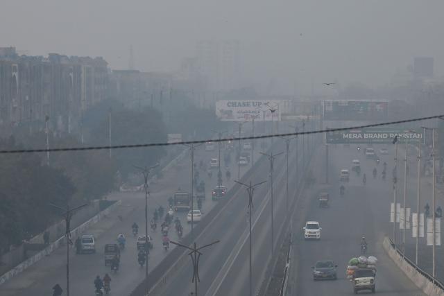 Commuters travel along a road amid foggy conditions in Karachi on January 16, 2026. (Photo by Rizwan TABASSUM / AFP)