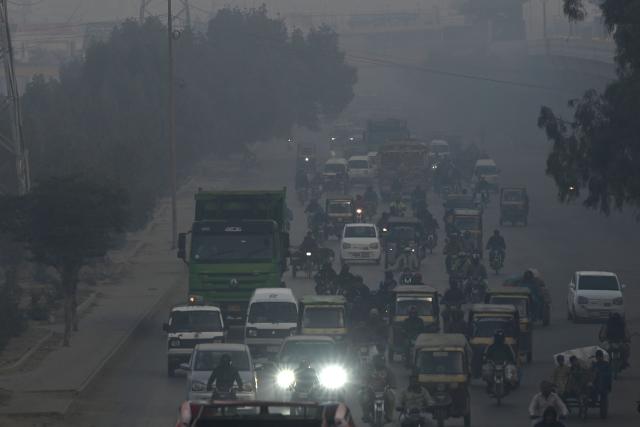 Commuters travel along a road amid foggy conditions in Karachi on January 16, 2026. (Photo by Rizwan TABASSUM / AFP)