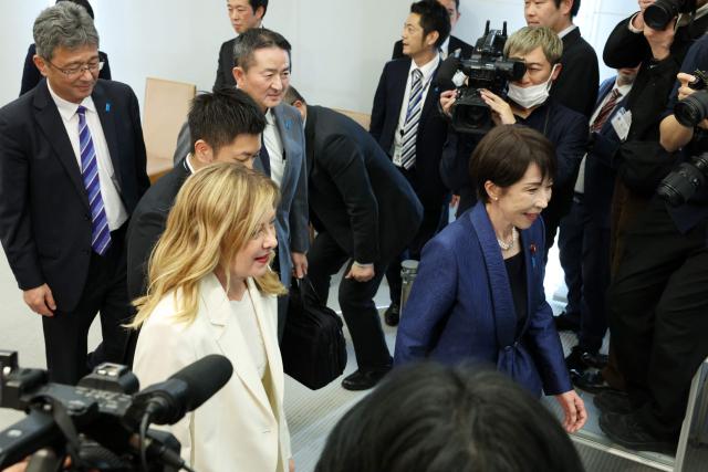 Italy's Prime Minister Georgia Meloni and Japan's Prime Minister Sanae Takaichi arrive for a meeting with Liberal Democratic Party (LDP) cabinet members Kimi Onoda and Satsuki Katayama ahead a roundtable with female cabinet members during the Japan-Italy summit meeting in Tokyo on January 16, 2026. (Photo by Takashi Aoyama / POOL / AFP)