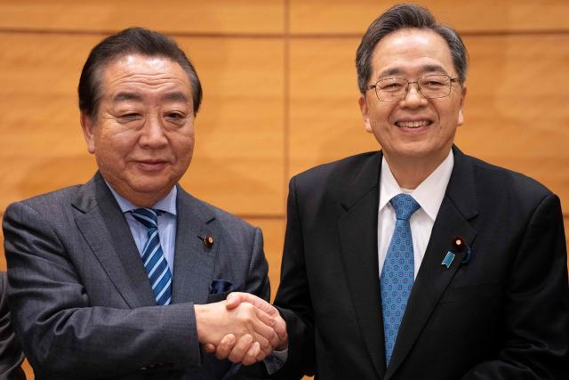 Leader of the Constitutional Democratic Party of Japan (CDP) Yoshihiko Noda (L) and Komeito leader Tetsuo Saito shake hands during a joint press conference to announce the new party name 'Centrist Reform Alliance' in Tokyo on January 16, 2026. (Photo by Yuichi YAMAZAKI / AFP)