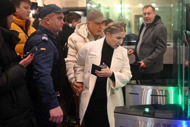 Former Ukraine's Prime Minister Yulia Tymoshenko (R) accompanied by her husband Oleksandr (L) arrives for a pre-trial hearing at a court in Kyiv on January 16, 2026, amid the Russian invasion of Ukraine. Former Ukraine's Prime Minister Yulia Tymoshenko said on January 14, 2026 her party's office had been raided overnight after anti-corruption bodies announced a sweeping probe into political corruption. (Photo by Sergei GAPON / AFP)