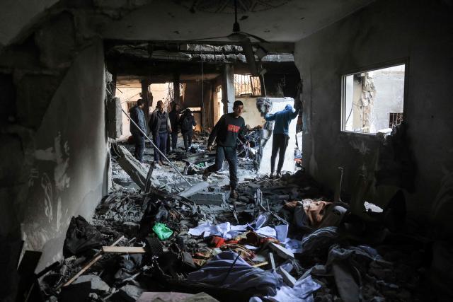 Palestinians survey the destruction of a house after an Israeli military attack on the home of the al-Houli family, in which four people were reportedly killed, west of Deir al-Balah, in the central Gaza Strip on January 16, 2026. A US-backed plan to end the war in Gaza has entered its second phase despite unresolved disputes between Israel and Hamas over alleged ceasefire violations and issues unaddressed in the first stage. (Photo by BASHAR TALEB / AFP)
