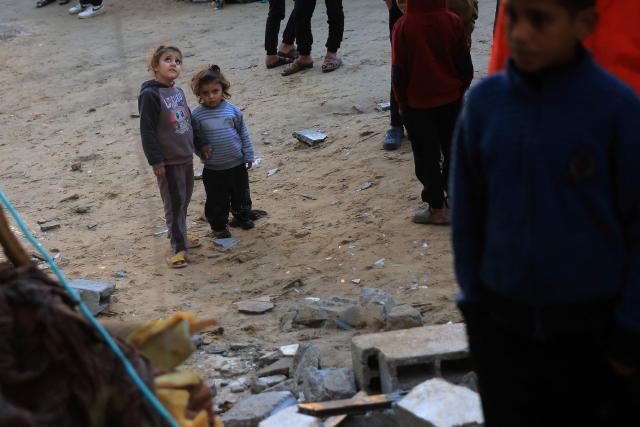 Palestinian children look at a destroyed house after an Israeli military attack on the home of the al-Houli family, in which four people were reportedly killed, west of Deir al-Balah, in the central Gaza Strip on January 16, 2026. A US-backed plan to end the war in Gaza has entered its second phase despite unresolved disputes between Israel and Hamas over alleged ceasefire violations and issues unaddressed in the first stage. (Photo by BASHAR TALEB / AFP)