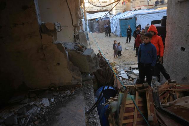 Palestinian children inspect a destroyed house after an Israeli military attack on the home of the al-Houli family, in which four people were reportedly killed, west of Deir al-Balah, in the central Gaza Strip on January 16, 2026. A US-backed plan to end the war in Gaza has entered its second phase despite unresolved disputes between Israel and Hamas over alleged ceasefire violations and issues unaddressed in the first stage. (Photo by BASHAR TALEB / AFP)