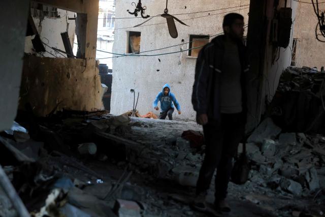 A Palestinian enters a destroyed house after an Israeli military attack on the home of the al-Houli family, in which four people were reportedly killed, west of Deir al-Balah, in the central Gaza Strip on January 16, 2026. A US-backed plan to end the war in Gaza has entered its second phase despite unresolved disputes between Israel and Hamas over alleged ceasefire violations and issues unaddressed in the first stage. (Photo by BASHAR TALEB / AFP)