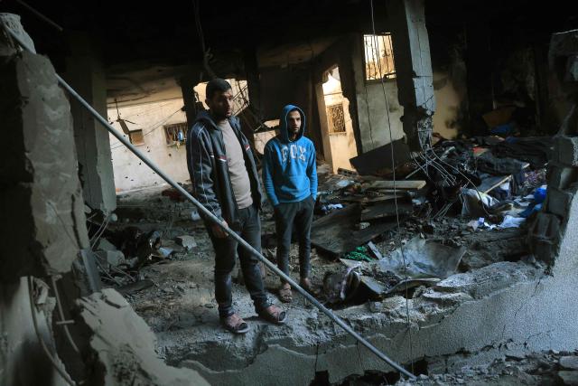Palestinians look on after inspecting a destroyed house after an Israeli military attack on the home of the al-Houli family, in which four people were reportedly killed, west of Deir al-Balah, in the central Gaza Strip on January 16, 2026. A US-backed plan to end the war in Gaza has entered its second phase despite unresolved disputes between Israel and Hamas over alleged ceasefire violations and issues unaddressed in the first stage. (Photo by BASHAR TALEB / AFP)