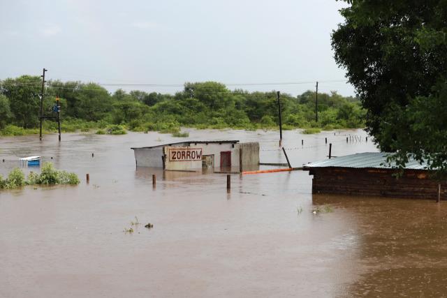 TOPSHOT - A general view of building and an informal structure submerged in floodwater in Giyani on January 16, 2026. Flooding triggered by torrential rains in northeastern South Africa claimed at least 10 lives overnight and forced the closure of the iconic Kruger National Park, officials said on January 15, 2026. 
The weather service issued the maximum warning for more rain in parts of the country while neighbouring Mozambique was also on alert after flooding that inundated roads and homes. (Photo by Orlando Chauke / AFP)