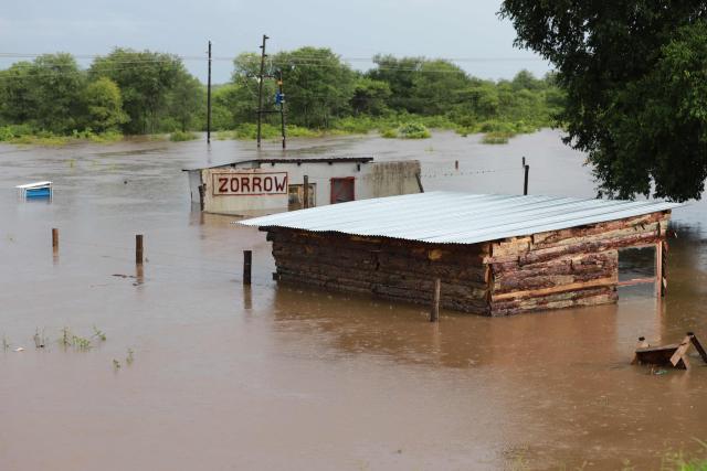 A general view of building and an informal structure submerged in floodwater in Giyani on January 16, 2026. Flooding triggered by torrential rains in northeastern South Africa claimed at least 10 lives overnight and forced the closure of the iconic Kruger National Park, officials said on January 15, 2026. 
The weather service issued the maximum warning for more rain in parts of the country while neighbouring Mozambique was also on alert after flooding that inundated roads and homes. (Photo by Orlando Chauke / AFP)