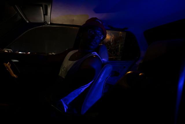 Laurence Nyoni poses for a portrait in his car at the Wheelz’n Smoke Arena in south Johannesburg, on January 15, 2026. Ayanda Mbele and her partner, Monde Hashe, founded the Wheelz’n Smoke Arena to create a safe space for spinners, after a lack of protections at informal spinning spots contributed to the sport’s former illegal status. Once held illegally on Thursday nights, spinning events now continue legally at the Wheelz’n Smoke Arena. (Photo by CAMILLA RICHETTI / AFP)