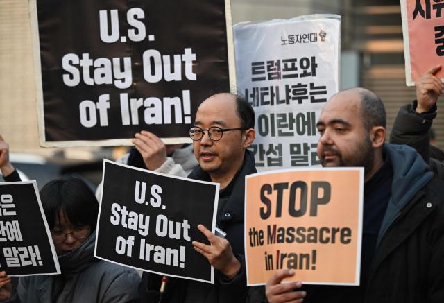 Protesters hold placards during a demonstration against the Iranian regime in front of the Iranian embassy in Seoul on January 16, 2026. (Photo by Jung Yeon-je / AFP)