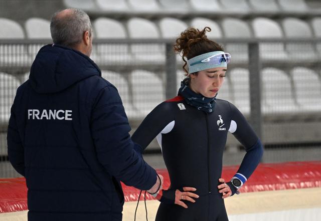 Speed Skater Violette Braun of France talks to her coach Alain Negre during a training session in Inzell, southern Germany, on January 13, 2026. France’s speed skating team leader Timothy Loubineaud, a likely Olympic medal contender in Milan next month, is calling for the construction of a temporary long track ice rink dedicated to his sport for the 2030 Winter Games in the French Alps. (Photo by Christof STACHE / AFP)