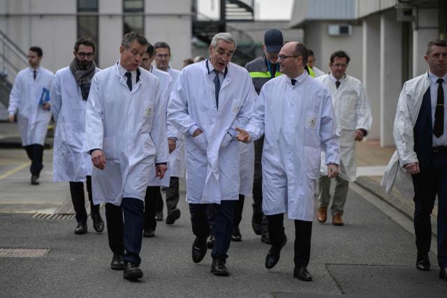 France’s junior Minister for industry Sebastien Martin (C,R) speaks with Pierre-Yves Revol (C) chairman of Pierre Fabre Participations as he visits the Pierre Fabre Laboratories during an event marking the 'commissioning of the production line for the strategic molecule against cutaneous melanoma', in Gaillac, southern France on January 16, 2026. (Photo by Ed JONES / AFP)