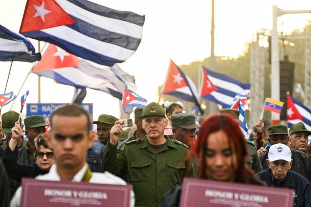 Cuba's President Miguel Diaz-Canel (C) takes part in the "Anti-Imperialist" protest in front of the US Embassy against the US incursion in Venezuela, where 32 Cuban soldiers lost their lives, in Havana on January 16, 2026. The capture by US forces of Venezuelan leader Nicolas Maduro on January 3, 2026, and the killing in the operation of 32 Cubans assigned to protect him represent a major blow for the island's revered intelligence services, experts say. (Photo by YAMIL LAGE / POOL / AFP)