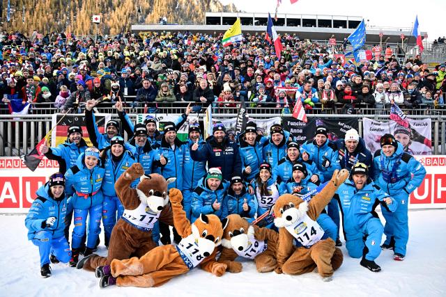 Third placed Italy's Lisa Vittozzi (3rd R, bottom row) celebrate with the team after winning the women's 7.5km sprint competition of the IBU Biathlon World Cup in Ruhpolding, southern Germany on January 16, 2026. (Photo by Tobias SCHWARZ / AFP)