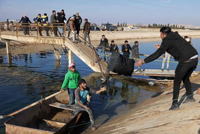 People walk across a damaged bridge as they flee from a Kurdish-controlled area, in Rasm al-Harmal, east of Aleppo city on January 16, 2026. Civilians fled a Kurdish-held region of northern Syria on January 16 before a deadline set by the army, which seeks to expand its control over the area after driving Kurdish forces from Aleppo. The government is seeking to extend its authority nationwide following the ousting of longtime leader Bashar al-Assad in December 2024. (Photo by Bakr ALkasem / AFP)