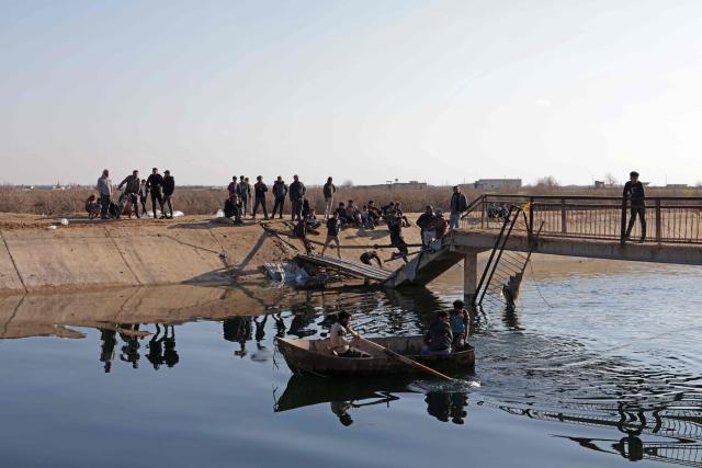 People walk across a damaged bridge as they flee from a Kurdish-controlled area, in Rasm al-Harmal, east of Aleppo city on January 16, 2026. Civilians fled a Kurdish-held region of northern Syria on January 16 before a deadline set by the army, which seeks to expand its control over the area after driving Kurdish forces from Aleppo. The government is seeking to extend its authority nationwide following the ousting of longtime leader Bashar al-Assad in December 2024. (Photo by Bakr ALkasem / AFP)