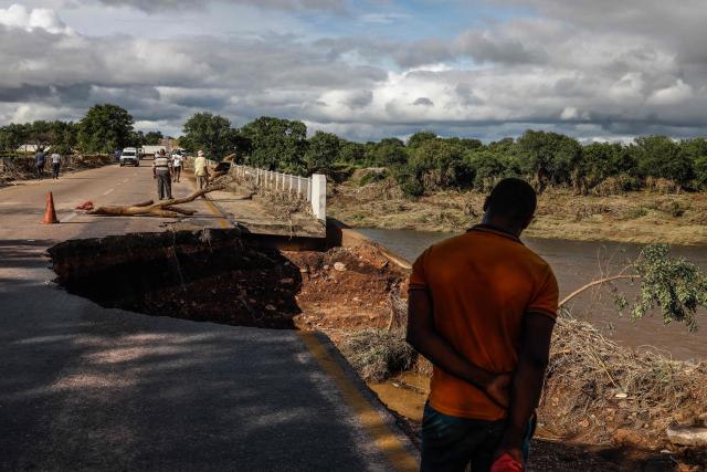 Onlookers inspect damage to the bridge crossing the Ga-Selati River, just outside Phalaborwa on January 16, 2026 following heavy rains over much of the Limpopo Province, South Africa. Heavy rains have drenched the northeast of the country since late last year, claiming at least 30 lives, with the region on maximum alert for more rain in the coming days. (Photo by Paul Botes / AFP)