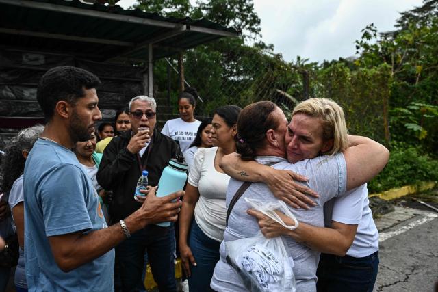 Mariana Gonzalez (R), daughter of exiled Venezuelan opposition figure Edmundo Gonzalez, hugs a woman after visiting her husband at El Rodeo I prison in Guatire, Miranda State, about 30 kilometers east of Caracas, on January 16, 2026. Venezuela has released a Czech detained in September 2024 with four Americans and two Spaniards over an alleged plot to assassinate then-president Nicolas Maduro, the Czech foreign minister said on January 16. (Photo by Ronaldo SCHEMIDT / AFP)