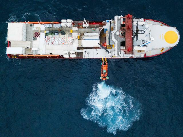 This aerial photograph shows crew members of the “Ocean Viking” rescue ship transfering migrants to the mothership using a RHIB (Rigid inflatable boat), in the search-and-rescue zone off the international waters of Libya, on January 16, 2026. 47 migrants on a rubber dinghy in distress are rescued by the crew of the "Ocean Viking" in international waters off the coast of Libya as they attempt to reach the shores of the Italian island of Lampedusa. Libya, located about 300 km from the Italian coast, is one of the main departure points in North Africa for migrants, mostly from sub-Saharan Africa, attempting to cross the Mediterranean at the risk of their lives. This is the first rescue of the year carried out by the ship operated by the NGO SOS Mediterranee. (Photo by Sameer Al-DOUMY / AFP)