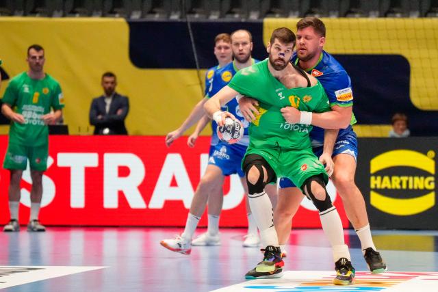 Montenegro's left back #87 Vuko Borozan is held during the men's EHF Euro 2026 preliminary round group D handball match Slovenia vs Montenegro in Oslo, Norway, on January 16, 2026. (Photo by Cornelius Poppe / NTB / AFP) / Norway OUT