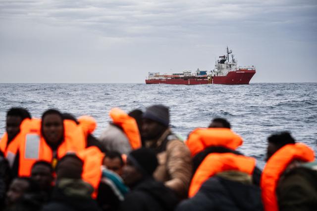 This photograph shows the migrant rescue ship the “Ocean Viking” as crew members carry out a rescue operation in the search-and-rescue zone off the international waters of Libya, on January 16, 2026. 46 migrants on a rubber dinghy in distress were rescued by the crew of the "Ocean Viking" in international waters off the coast of Libya as they attempted to reach the shores of the Italian island of Lampedusa. Libya, located about 300 km from the Italian coast, is one of the main departure points in North Africa for migrants, mostly from sub-Saharan Africa, risking their lives attempting to cross the Mediterranean sea. This is the first rescue of the year carried out by the ship operated by the NGO SOS Mediterranee. (Photo by Sameer Al-DOUMY / AFP)