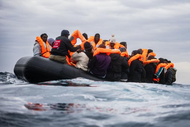 Migrants onboard a rubber boat wait as they are rescued by crew members of the “Ocean Viking” rescue in the search-and-rescue zone off the international waters of Libya, on January 16, 2026. 46 migrants on a rubber dinghy in distress were rescued by the crew of the "Ocean Viking" in international waters off the coast of Libya as they attempted to reach the shores of the Italian island of Lampedusa. Libya, located about 300 km from the Italian coast, is one of the main departure points in North Africa for migrants, mostly from sub-Saharan Africa, risking their lives attempting to cross the Mediterranean sea. This is the first rescue of the year carried out by the ship operated by the NGO SOS Mediterranee. (Photo by Sameer Al-DOUMY / AFP)
