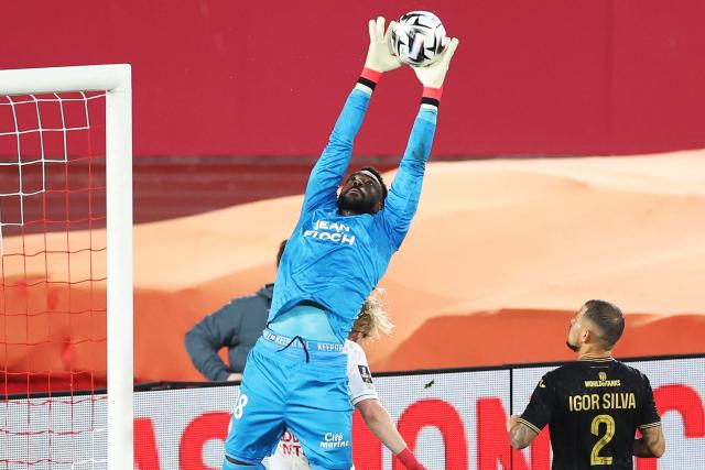 Lorient's Swiss goalkeeper #38 Yvon Mvogo stops the ball during the French L1 football match between AS Monaco and FC Lorient at the Stade Louis II in the Principality of Monaco on January 16, 2026. (Photo by Valery HACHE / AFP)