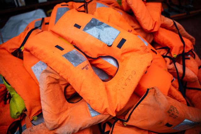This photograph shows life jackets awaiting disinfecting onboard the “Ocean Viking” rescue ship after crew members rescued 46 migrants in the search-and-rescue zone off the international waters of Libya, on January 16, 2026. The 46 migrants of a rubber dinghy in distress were rescued by the crew of the "Ocean Viking" in international waters off the coast of Libya as they attempted to reach the shores of the Italian island of Lampedusa. Libya, located about 300 km from the Italian coast, is one of the main departure points in North Africa for migrants, mostly from sub-Saharan Africa, risking their lives attempting to cross the Mediterranean sea. This is the first rescue of the year carried out by the ship operated by the NGO SOS Mediterranee. (Photo by Sameer Al-DOUMY / AFP)