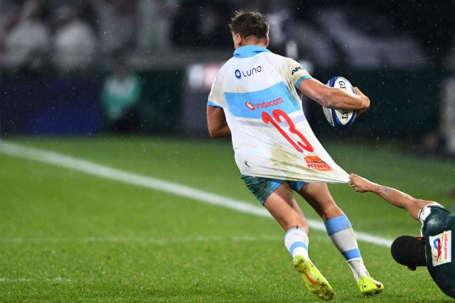 TOPSHOT - Bulls' South African centre Sebastian De Klerk attempts to break away from Pau's French wing Aaron Grandidier-Nkanang (R) during the European Champions Cup, first round, day 4, pool 4, rugby union match between Section Paloise (Pau) and Bulls (Pretoria) at the stade du Hameau in Pau, southern France, on January 16, 2026. (Photo by GAIZKA IROZ / AFP)