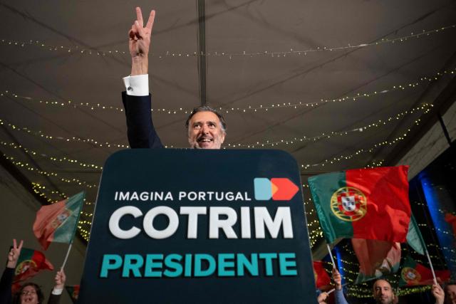 Liberal Initiative Party candidate for Portugal’s presidency, Joao Cotrim Figueiredo,  flashes the victory sign during a campaign dinner in Braga, northern Portugal, on January 16, 2026. Portugal will hold presidential elections on 18 January. (Photo by MIGUEL RIOPA / AFP)