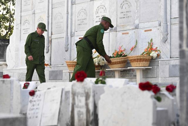 Cuban soldiers place flowers on the graves of some of the 32 Cuban soldiers killed during the US incursion in Venezuela during their funeral at Colon cemetery in Havana on January 16, 2026. The capture by US forces of Venezuelan leader Nicolas Maduro on January 3, 2026, and the killing in the operation of 32 Cubans assigned to protect him represent a major blow for the island's revered intelligence services, experts say. (Photo by Yamil LAGE / AFP)