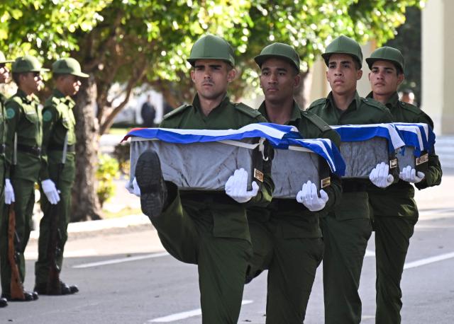 Cuban soldiers carry the remains of some of the 32 Cuban soldiers killed during the US incursion in Venezuela during their funeral at Colon cemetery in Havana on January 16, 2026. The capture by US forces of Venezuelan leader Nicolas Maduro on January 3, 2026, and the killing in the operation of 32 Cubans assigned to protect him represent a major blow for the island's revered intelligence services, experts say. (Photo by ADALBERTO ROQUE / AFP)