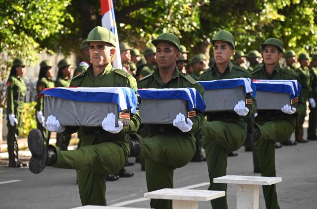 Cuban soldiers carry the remains of some of the 32 Cuban soldiers killed during the US incursion in Venezuela during their funeral at Colon cemetery in Havana on January 16, 2026. The capture by US forces of Venezuelan leader Nicolas Maduro on January 3, 2026, and the killing in the operation of 32 Cubans assigned to protect him represent a major blow for the island's revered intelligence services, experts say. (Photo by ADALBERTO ROQUE / AFP)