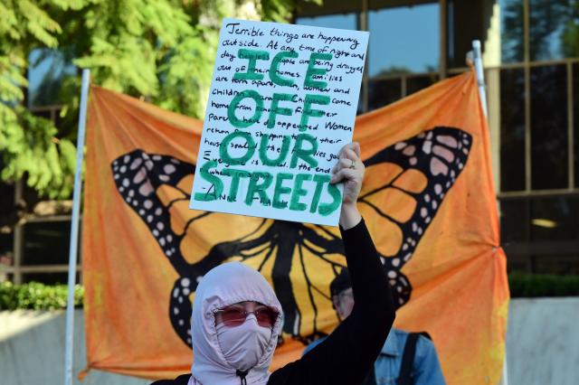 A protester holds a sign during a demonstration against ICE and US President Donald Trump's immigration crackdown outside the Federal Building in Los Angeles, California on January 16, 2026. (Photo by Frederic J. Brown / AFP)