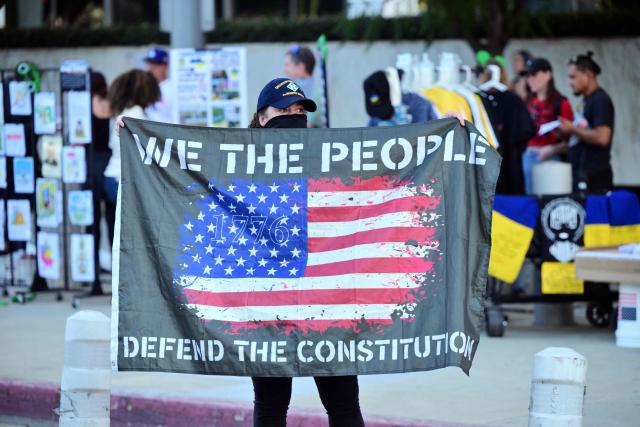 A protester displays a flag during a demonstration against ICE and US President Donald Trump's immigration crackdown outside the Federal Building in Los Angeles, California on January 16, 2026. (Photo by Frederic J. Brown / AFP)