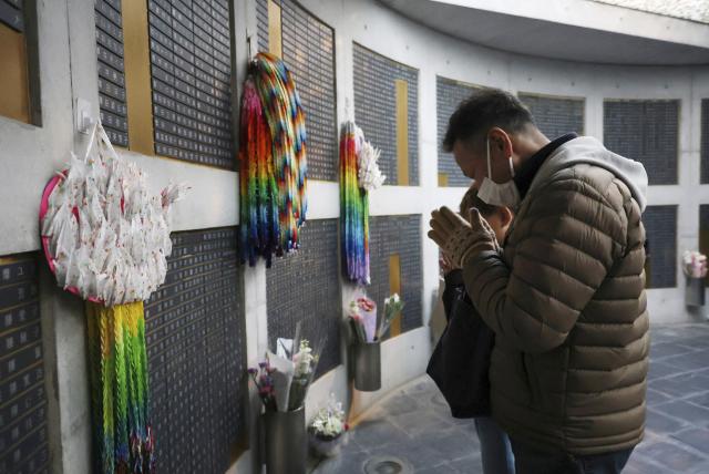 A man prays in front of the plaque of his mother, who was a victim of the Great Hanshin Earthquake, on the 31st anniversary of earthquake in Kobe, Hyogo prefecture on January 17, 2026. The port city of Kobe was hit by a 7.2 magnitude quake on January 17, 1995, killing 6,434 people and levelling much of the city. (Photo by JIJI PRESS / AFP) / Japan OUT