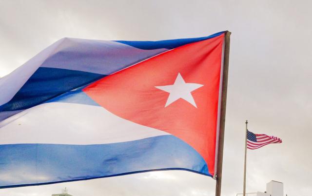 A Cuban soldier waves a national flag as he takes part in the "Anti-Imperialist" protest in front of the US Embassy against the US incursion in Venezuela, where 32 Cuban soldiers lost their lives, in Havana on January 16, 2026. The capture by US forces of Venezuelan leader Nicolas Maduro on January 3, 2026, and the killing in the operation of 32 Cubans assigned to protect him represent a major blow for the island's revered intelligence services, experts say. (Photo by ADALBERTO ROQUE / AFP)