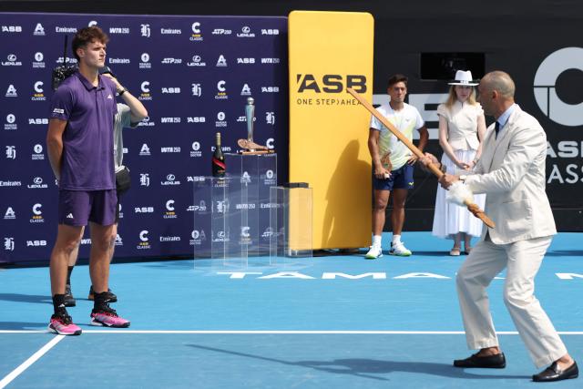 Czech Republic's Jakub Mensik is presented a traditional Maori spear in a ceremony after his victory against Argentina's Sebastian Baez in their men's singles final match at the ATP Auckland Classic tennis tournament in Auckland on January 17, 2026. (Photo by Michael Bradley / AFP)