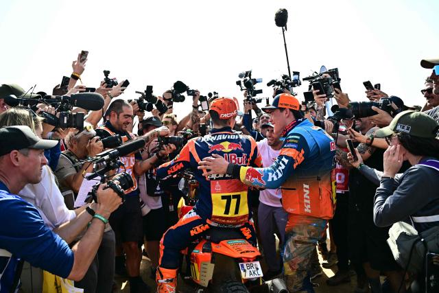 Media personnel gather around Argentine rider Luciano Benavides (C) with a Ktm 450 Rally Factory after he won the 48th edition of the Dakar Rally 2026 in Yanbu, Saudi Arabia, on January 17, 2026. (Photo by Giuseppe CACACE / AFP)