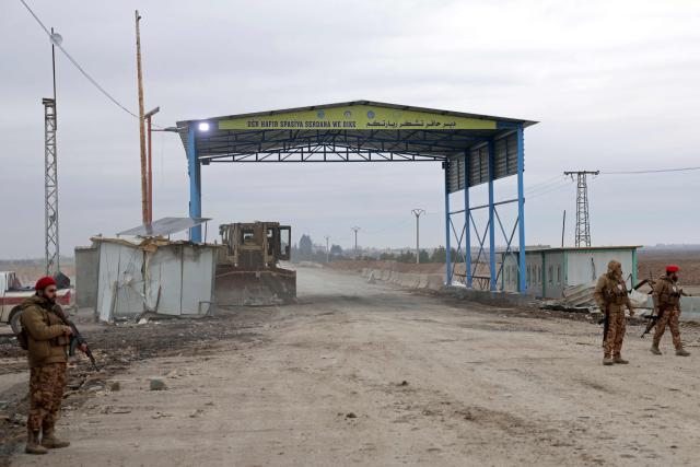 Syrian army soldiers stand guard at the entrance of the Deir Hafer town on January 17, 2026. Syria's army said it took control of the town of Deir Hafer outside Aleppo city on January 17, a day after Kurdish forces agreed to withdraw from the area following recent clashes. In a statement to state television, the army said it had established "full military control" of Deir Hafer, while an AFP correspondent on the ground saw troops deploying inside the town. (Photo by Bakr ALkasem / AFP)